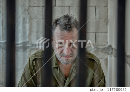 The Price of War: Striking Image Reveals Toll of Conflict on Elderly Inmate in Military Uniform. 117580985
