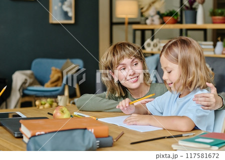 Proud mom supporting her daughter while she drawing Proud mom supporting her daughter while she drawing 117581672