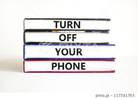 Turn off your phone symbol. Concept words Turn off your phone on books. Beautiful white table white background. Business psychological turn off your phone concept. Copy space Turn off your phone symbol. Concept words Turn off your phone on books. Beautiful white table white background. Business psychological turn off your phone concept. Copy space 117581763