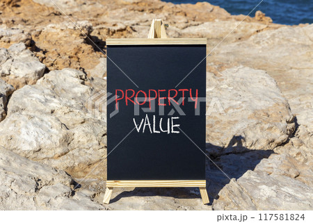 Property value symbol. Concept words Property value on beautiful black chalk blackboard. Beautiful stone beach blue sea sky background. Business property value concept. Copy space. 117581824