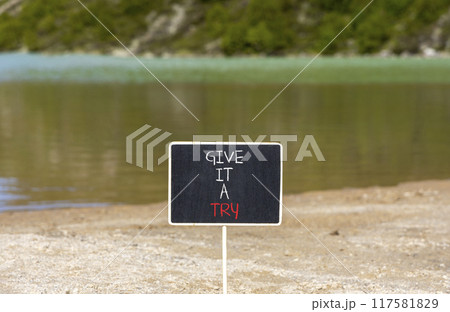 Give it a try symbol. Concept word Give it a try on beautiful black chalk blackboard. Beautiful mountain lake background. Business give it a try concept. Copy space. 117581829