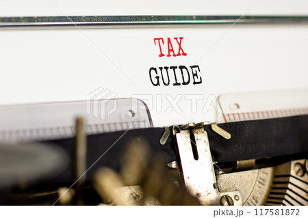 Tax guide symbol. Concept words Tax guide typed on beautiful old retro typewriter. Beautiful white background. Business and Tax guide concept. Copy space. 117581872