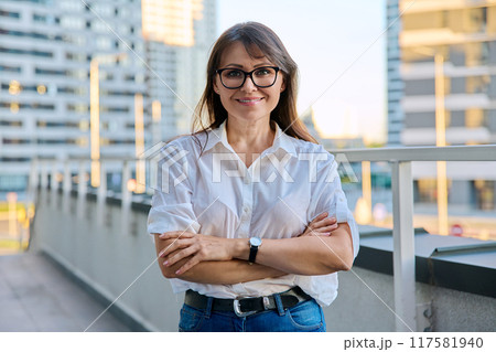 Portrait of middle-aged confident woman posing outdoors 117581940