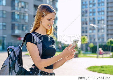 Young teenage female using smartphone, modern city background 117581962