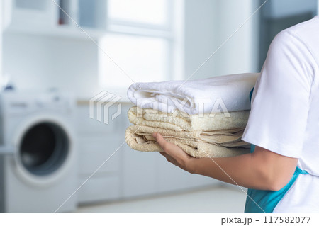 Cleaning lady aprons holding a pack of clean towels. 117582077