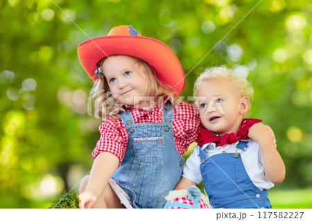 Cowboy kids playing with toy horse 117582227
