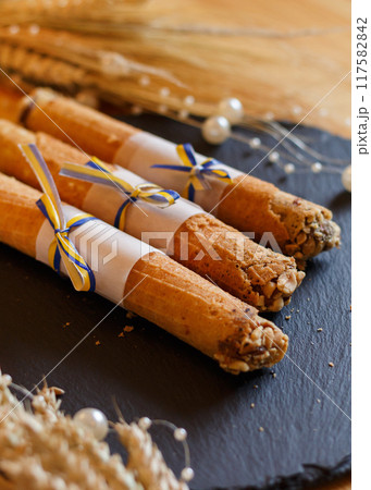 Handmade brown aromatic soap with cinnamon, dried fruits lies cosily on wood with lights. aroma postcard, close-up, vertical 117582842