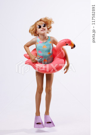 Happy child with inflatable duck ring on blue background with copy space. 117582891