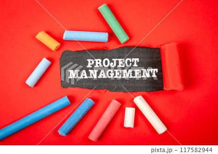 Project management. Text under torn red paper on a blackboard Project management. Text under torn red paper on a blackboard 117582944