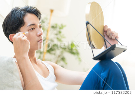 リビングでメイクをする若い男性 117583203