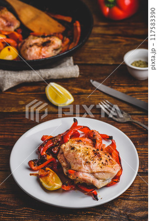 Baked chicken thighs with red bell peppers and lemon Baked chicken thighs with red bell peppers and lemon 117583390