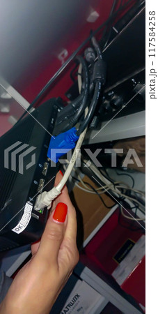 Network connection of a personal computer. A workspace with a compact PC and lots of connection cables. 117584258