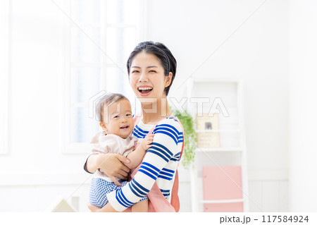 赤ちゃんを抱く保育士 117584924