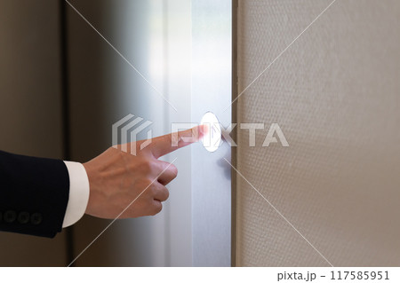 エレベーターのボタンを押すビジネスマン　手元 117585951