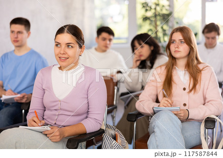 Young female student listening to lecture with focus 117587844