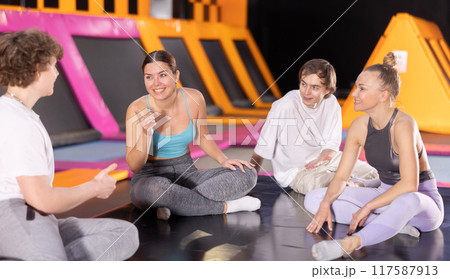Two women and two teenager boys talking in trampoline center Two women and two teenager boys talking in trampoline center 117587913