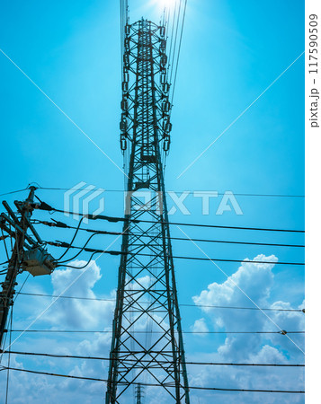 交差する高圧送電線と住宅街の電線と夏の空　ライトカラー 117590509