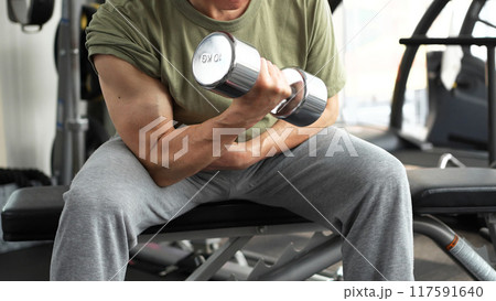 ダンベルアームカールで腕を鍛える男性 117591640