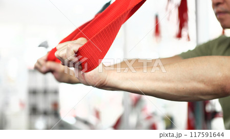 サスペンショントレーニングで体幹を鍛える男性 117591644