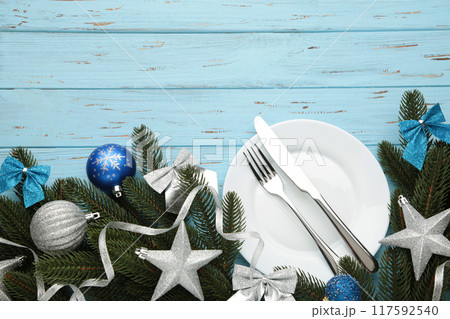 Christmas table place setting with blue and silver decoration on blue. Holidays background 117592540
