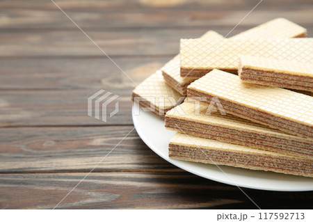 Chocolate wafers on plate on brown background Chocolate wafers on plate on brown background 117592713