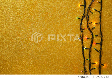 Christmas garland lights on gold glitter background. 117592748