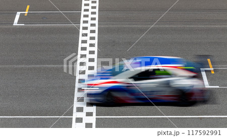 Motion blur race car racing on speed track, Car race on the international circuit race track crossing start and finish line, Race car crossing start and finish line, Target business achieve. Motion blur race car racing on speed track, Car race on the international circuit race track crossing start and finish line, Race car crossing start and finish line, Target business achieve. 117592991