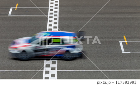 Motion blur race car racing on speed track, Car race on the international circuit race track crossing start and finish line, Race car crossing start and finish line, Target business achieve. Motion blur race car racing on speed track, Car race on the international circuit race track crossing start and finish line, Race car crossing start and finish line, Target business achieve. 117592993