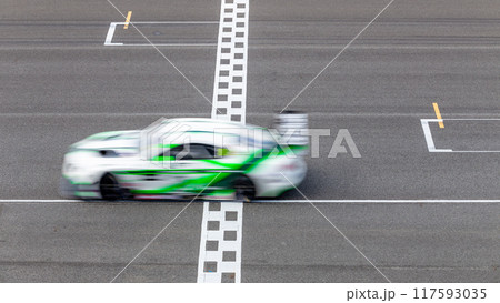 Motion blur race car racing on speed track, Car race on the international circuit race track crossing start and finish line, Race car crossing start and finish line, Target business achieve. 117593035