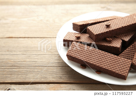 Chocolate wafers with coffee in plate on grey wooden background. 117593227