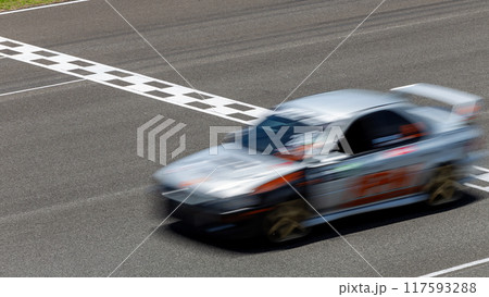 Motion blur race car racing on speed track, Car race on the international circuit race track crossing start and finish line, Race car crossing start and finish line, Target business achieve victory. 117593288