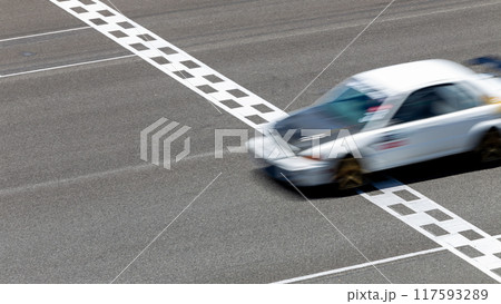 Motion blur race car racing on speed track, Car race on the international circuit race track crossing start and finish line, Race car crossing start and finish line, Target business achieve victory. Motion blur race car racing on speed track, Car race on the international circuit race track crossing start and finish line, Race car crossing start and finish line, Target business achieve victory. 117593289