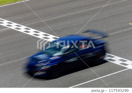 Motion blur race car racing on speed track, Car race on the international circuit race track crossing start and finish line, Race car crossing start and finish line, Target business achieve victory. Motion blur race car racing on speed track, Car race on the international circuit race track crossing start and finish line, Race car crossing start and finish line, Target business achieve victory. 117593290
