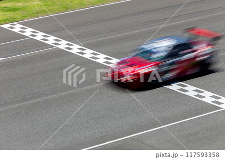 Motion blur race car racing on speed track, Car race on the international circuit race track crossing start and finish line, Race car crossing start and finish line, Target business achieve victory. Motion blur race car racing on speed track, Car race on the international circuit race track crossing start and finish line, Race car crossing start and finish line, Target business achieve victory. 117593358