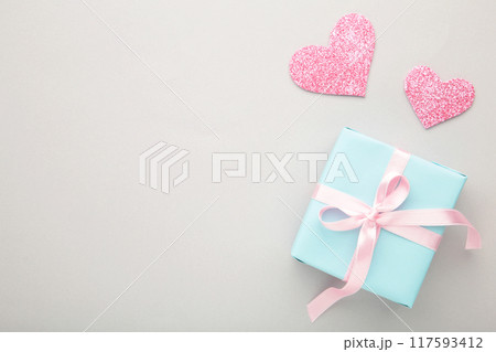 Valentines day background with pink hearts and gift box on grey background. Top view. 117593412