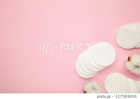 Hygienic disposable product cosmetic pads and cotton flower on pink background 117593650