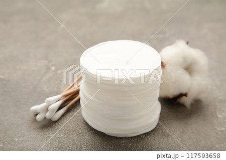 Hygienic disposable product cosmetic pads and cotton flower on grey background Hygienic disposable product cosmetic pads and cotton flower on grey background 117593658