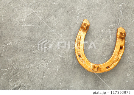 Gold horseshoe on grey background. St. Patricks day Gold horseshoe on grey background. St. Patricks day 117593975