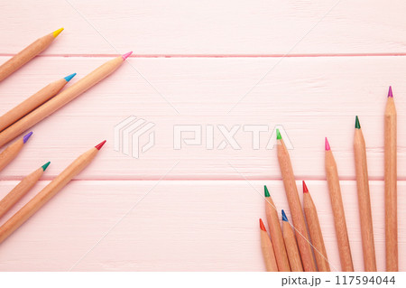 Colored pencils on the pink wooden background. Colored pencils on the pink wooden background. 117594044