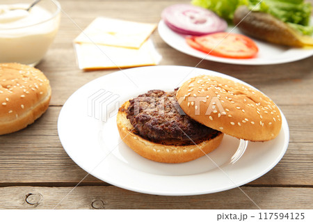 Bun and veal patty ingredient hamburger in plate on grey table Bun and veal patty ingredient hamburger in plate on grey table 117594125