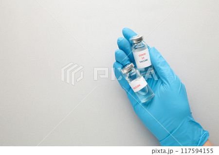 Medical doctor holding two tube with Coronavirus vaccine for 2019-nCoV COVID virus on grey background. 117594155