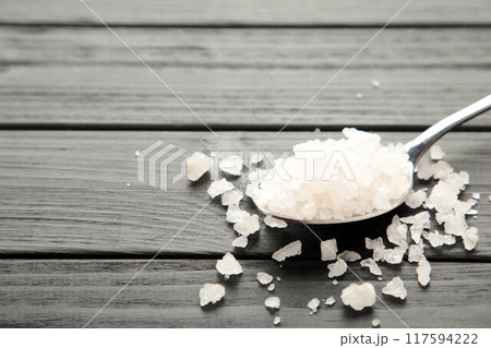 Sea salt in spoon on black background 117594222