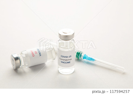 Coronavirus COVID-19 vaccine vials and syringe on grey background with copy space. Coronavirus COVID-19 vaccine vials and syringe on grey background with copy space. 117594257