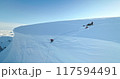 Group of people relax Antarctica glacier aerial view. Snow-covered slope, blue sky in sunny day. Discover South Pole beauty. Antarctica travel, expedition, exploration. Man digging snow with shovel 117594491