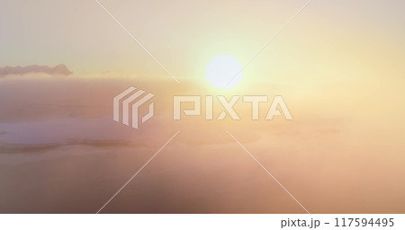Colorful sunrise over Antarctica ocean coast. Aerial drone flight above telecom engineer maintenance cell signal antenna from polar base station. Morning orange bright fog background. Nature wallpaper 117594495