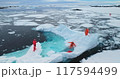 People on large floating ice iceberg in Antarctica. Scientists from polar station expedition outdoor. Icy landscape, melting glacier, wild nature of South Pole. Aerial shot 117594499