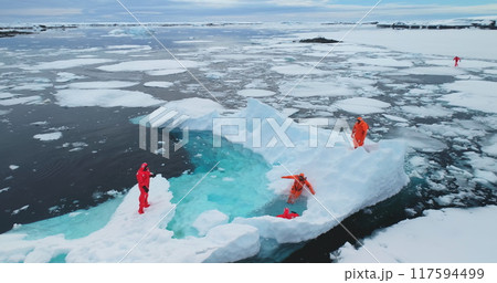 People on large floating ice iceberg in Antarctica. Scientists from polar station expedition outdoor. Icy landscape, melting glacier, wild nature of South Pole. Aerial shot People on large floating ice iceberg in Antarctica. Scientists from polar station expedition outdoor. Icy landscape, melting glacier, wild nature of South Pole. Aerial shot 117594499