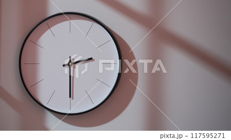 Elegant Black Clock Showing 14.30/02.30 with Shadows on Minimalist Wall - Ideal for Time Management and Interior Design Promotions Elegant Black Clock Showing 14.30/02.30 with Shadows on Minimalist Wall - Ideal for Time Management and Interior Design Promotions 117595271