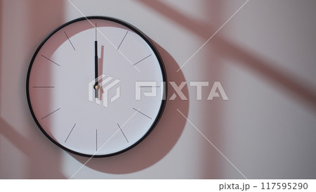 Elegant Black Clock Showing 12.00/0.00/24.00 with Shadows on Minimalist Wall - Ideal for Time Management and Interior Design Promotions 117595290