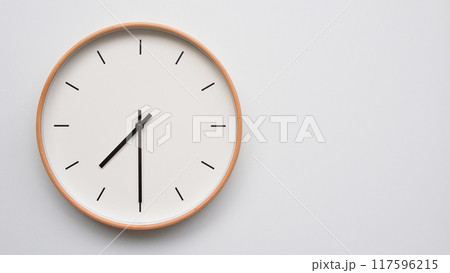 Minimalist wooden Wall Clock on White Wooden Surface with Space for Text.  Time Set at 19.30/07.30 117596215